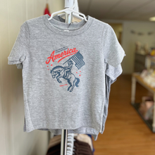 Load image into Gallery viewer, Gray toddler t-shirt with 'America' graphic design on a hanger inside Gracie Lou children's boutique