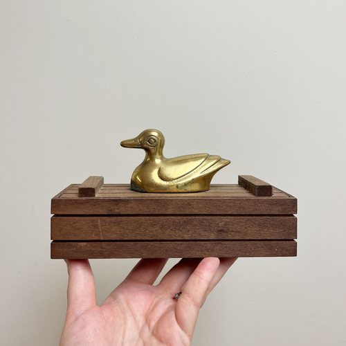 Domino set with brass duck on top of a wood box