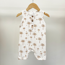 Load image into Gallery viewer, A baby romper in white with a brown palm tree pattern, hanging on a wooden hanger against a light gray background.