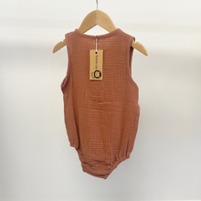 Load image into Gallery viewer, An infant size, baby boy bubble romper in the color brown, on a baby hanger in front of a white wall.