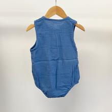 Load image into Gallery viewer, The back of an infant size blue cotton bubble romper on a baby hanger in front of a white background.