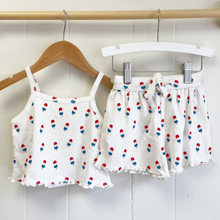 Load image into Gallery viewer, White pointelle baby top and shorts set with bomb pop popsicle print on hangers against a white background.