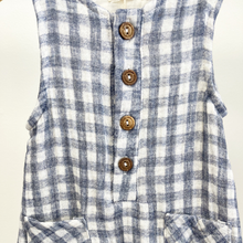 Load image into Gallery viewer, Close up details of the buttons on the front of a blue and white gingham baby boy jumpsuit on a wooden hanger in front of a white background.