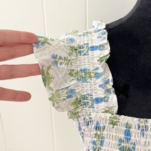 Load image into Gallery viewer, Floral patterned dress sleeve held by a hand against a white background