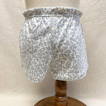 Load image into Gallery viewer, The back of floral toddler shorts on a mannequin against a beige background