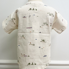 Load image into Gallery viewer, The back of a short-sleeve toddler t-shirt in cream with a delicate, all-over watercolor-style print of boats, sailboats, ships, and small trees. The shirt features a classic crew neck and a left chest pocket, styled on a mannequin.