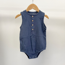 Load image into Gallery viewer, A blue cotton bubble romper on a baby hanger in front of a white background.