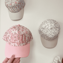 Load image into Gallery viewer, Pink cap with floral design and 'MAMA' text held by a hand, with two other caps with floral patterns on a light background.
