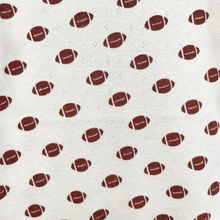 Load image into Gallery viewer, A close-up of a white cotton pointelle textured fabric with a repeating pattern of brown American footballs and small white dotted diamond shapes.
