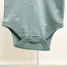 Load image into Gallery viewer, Teal baby onesie with small white golf cart and golf flag graphics on a beige background