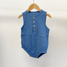 Load image into Gallery viewer, A blue cotton bubble romper on a baby hanger in front of a white background.
