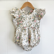 Load image into Gallery viewer, Floral baby romper on a wooden hanger against a white background inside the childrens boutique, Gracie Lou