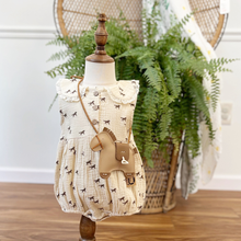 Load image into Gallery viewer, A western inspired baby girl bubble romper styled on an infant mannequin wearing a horse crossbody in front of a fern and wicker peacock chair.