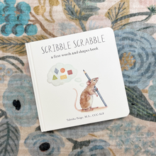 Load image into Gallery viewer, Children's book titled 'Scribble Scrabble' on a floral-patterned surface