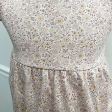 Load image into Gallery viewer, A close up of the floral bubble romper with flutter sleeves on a baby mannequin in front of a white wall.