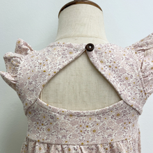 Load image into Gallery viewer, A floral bubble romper with flutter sleeves and an open back on a baby mannequin in front of a white wall.