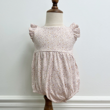 Load image into Gallery viewer, A floral bubble romper with flutter sleeves on a baby mannequin in front of a white wall.