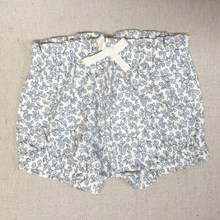 Load image into Gallery viewer, Floral-patterned bloomer shorts on a beige fabric background