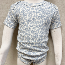Load image into Gallery viewer, Short-sleeve baby bodysuit with blue floral pattern on a mannequin against a beige background