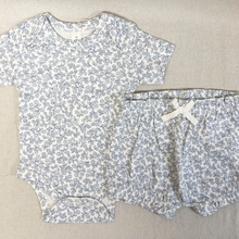 Load image into Gallery viewer, Baby romper and bloomers with blue floral pattern on a beige fabric background