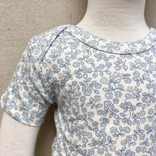 Load image into Gallery viewer, blue floral pattern bodysuit on a baby 
mannequin against a beige background
