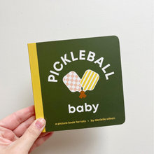 Load image into Gallery viewer, Book titled 'Pickleball Baby' held by a hand on a light gray background