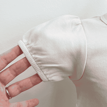 Load image into Gallery viewer, Close-up of a puff sleeve on the A-line tee shirt in the color Shell.