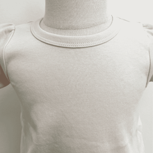 Load image into Gallery viewer, Close-up of a shell (combination of beiege, blush, and peach)  shirt on a mannequin with a light gray background