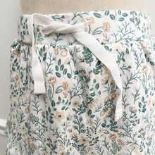 Load image into Gallery viewer, Close up photo of the tie-waist of the toddler size (2T and up) floral patterned skirt.