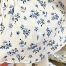 Load image into Gallery viewer, White cotton fabric with blue floral pattern on a baby mannequin