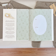 Load image into Gallery viewer, An open book, called I've Loved You From The Start, laid flat on a knit sweater, with a wooden surface visible at the bottom. The left page tells about the story with a small illustration, and the right page has a large white oval for dedication of the book to a loved one.