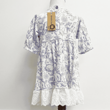 Load image into Gallery viewer, The back of the white dress with blue floral and bunny pattern on a mannequin against a white background