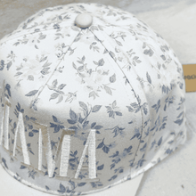 Load image into Gallery viewer, White cap with floral pattern on a light gray background
