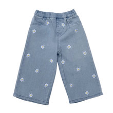 Load image into Gallery viewer, Light wash blue denim pants with white daisy flowers on a white background.